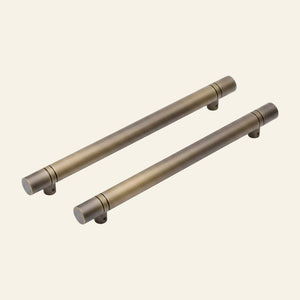 Two solid brass pull handles with a dark bronze finish, laying on a grey surface, with text indicating Sizes Available;s available: 30mm & 40mm C/C.