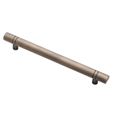 Two cylindrical cabinet handles on a white background, one in brushed bronze and one in matte black, with the bronze handle in the foreground.