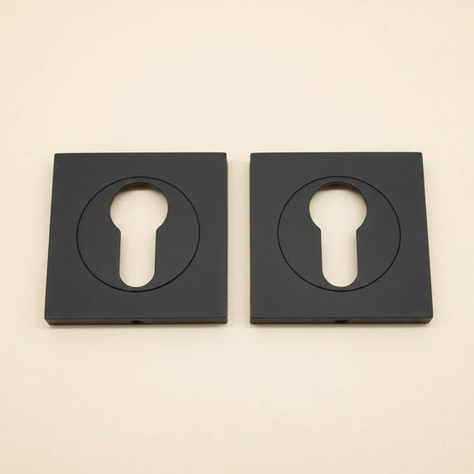 Two black solid brass square key plates with a powder coated finish, displayed on a white background.