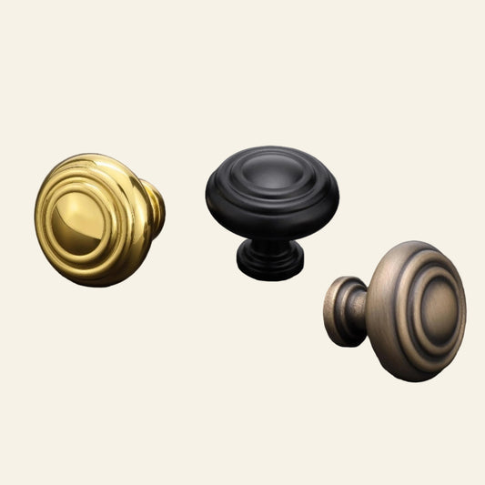 Three door knobs in polished brass, powder-coated black, and English bronze on a dark background with AceLine branding.