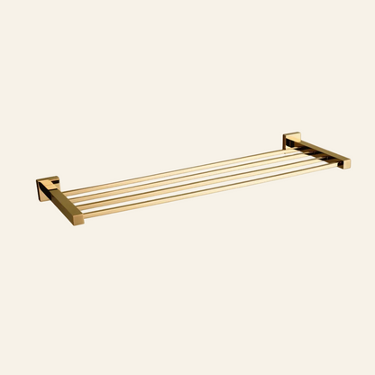 A modern wall-mounted towel bar with a four-bar slatted design in a polished gold finish, shown against a plain white background.