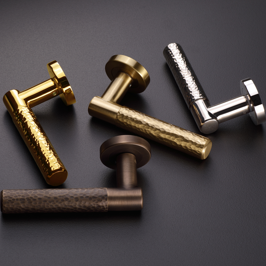 AceLine Max Series Set of metallic door handles in gold, bronze, and silver on a dark background