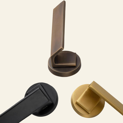 Three door handles in bronze, black, and yellow on a gray stone surface with AceLine logo.
